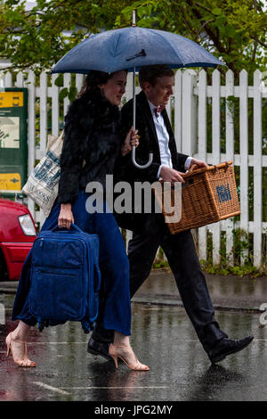 Lewes, UK. 2. August 2017. Großbritannien Wetter. Junge Menschen kommen zu Lewes Bahnhof im Regen auf dem Weg zum Glyndebourne Opera House für eine Aufführung von Don Pasquale, Lewes, East Sussex, UK. Bildnachweis: Grant Rooney/Alamy Live-Nachrichten Stockfoto