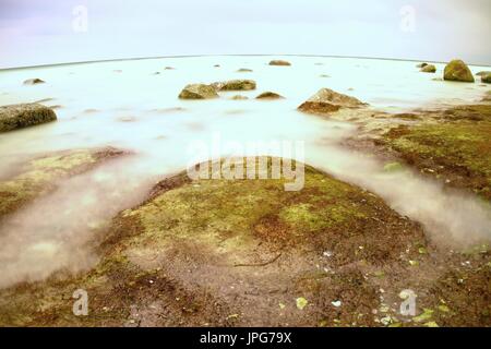 Die neblige Seenlandschaft in Ebb. Kalte Frühlingswetter Stockfoto