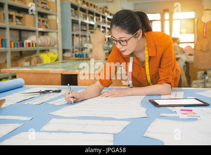 authentisches Foto Mode Frau Designer Zeichnung Design sketch arbeiten in Muster Büro Studio schriftliche Notiz mit mobilen Computer zeigen, Beruf Stockfoto