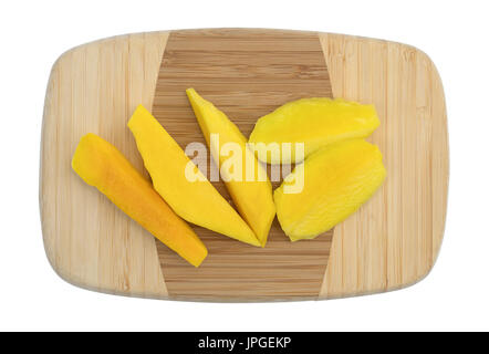 Draufsicht auf mehrere Scheiben frisch geschnittene Mango auf einem kleinen Holz Schneidebrett isoliert auf einem weißen Hintergrund. Stockfoto