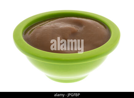 Eine Portion Birnen und Brombeere Bio Püree Babynahrung in einer grünen Schale isoliert auf einem weißen Hintergrund. Stockfoto