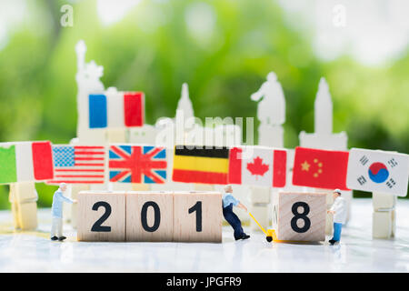 Arbeitnehmer sind, übertragen oder ziehen eine Holz-Nummer 8 mit Anzahl 2018 mit internationalen Flaggen Link Hintergrund als frohes neues Jahr 2018, Teamarbeit Stockfoto