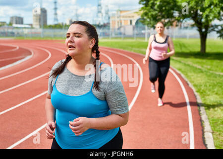 Dicke Frau gehen trotz Müdigkeit laufen erschöpft Stockfoto