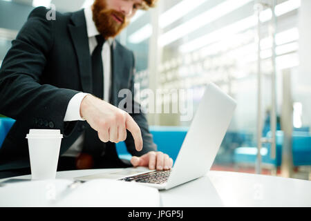 Closeup des Kaufmanns Taste am Laptop-Tastatur während der Arbeit in modernen Büro erschossen Stockfoto