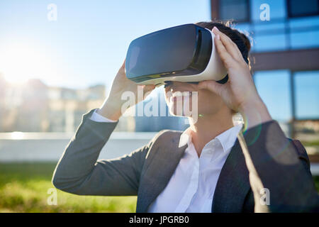 Junge Frau trägt Vr Kopfhörer und intelligente Viedeo Stockfoto