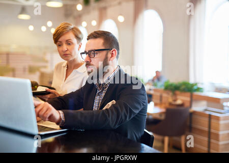 Besitzer des Restaurant, Kellnerin erklären, Änderungen im Online-Menü Stockfoto