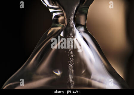 Sanduhr und Sand unten fallen. Makro Foto Stockfoto