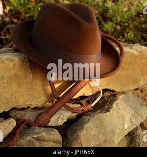 Fedora Hut und Peitsche auf einem antiken Stonewall. Wo ist Indiana? Stockfoto