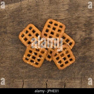 Eine Portion braune gesalzene Waffel Brezeln auf ein altes Holzbrett. Stockfoto