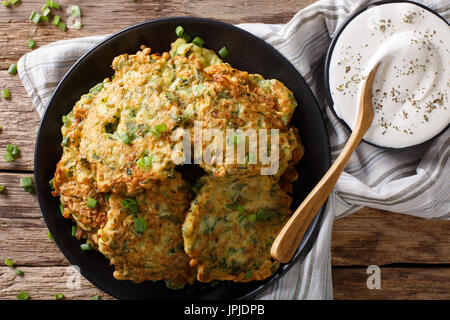 Frisch gekochte Zucchini Pfannkuchen mit Sauerrahm Nahaufnahme auf dem Tisch. Horizontale Ansicht von oben Stockfoto