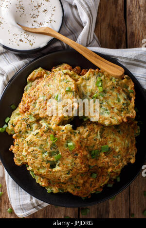 Frisch gekochte Zucchini Pfannkuchen mit Sauerrahm Nahaufnahme auf dem Tisch. Vertikale Ansicht von oben Stockfoto