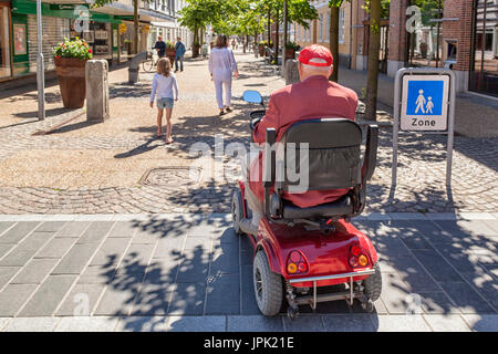 Ansicht der Rückseite des alten Mannes auf Mobilität scooter an der High Street Fußgängerzone nur, Frederikshavn, Dänemark Model Release: Nein Property Release: Nein Info: Entfernt Aufkleber auf Mobilität scooter und blau Straßenschild auf der rechten Seite. Stockfoto