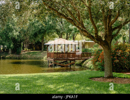 Die einen ruhigen, abgeschiedenen Pavillon aus Holz auf einem kleinen See in einem Wohngebiet Unterteilung in Florida, USA. Stockfoto