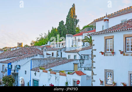 Das Straßenbild der mittelalterliche Obidos mit weißen Häusern, alte Fliesen, Dächer und Mauern der steinerne Festung rund um die Stadt, Portugal. Stockfoto