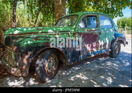 Ein altes Peugeot Auto unter einem Baldachin von Reben in einem Land am Mittelmeer Stockfoto