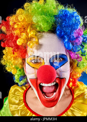 Verrückter Clown auf schwarzem Hintergrund. Porträt der verrückte Frau. Stockfoto