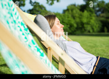 Frau, genießen Sie die Sonne in Chaiselongue. Stockfoto