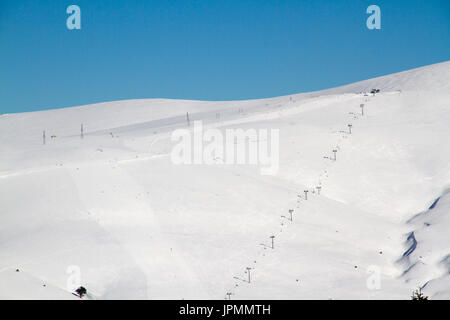 Loipen auf dem Hintergrund der schneebedeckten Berge und blauer Himmel Stockfoto