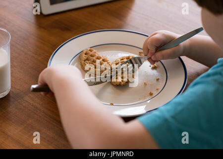 Bild eines jungen am Tisch frühstücken beschnitten Stockfoto