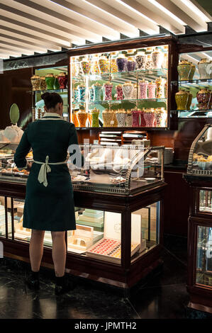 Mailand, Galleria Vittorio Emanuele II: eine Kellnerin am Schalter der Pasticceria Marchesi, historische Konditorei seit 1824 in der Prada-boutique Stockfoto