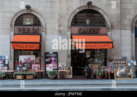 Frauen sitzen auf einem Tisch außerhalb der Caffè Verdi, eine Cafeteria und ein Restaurant in der Nähe von La Scala oder Teatro Alla Scala, der berühmteste Opernhaus in Italien Stockfoto