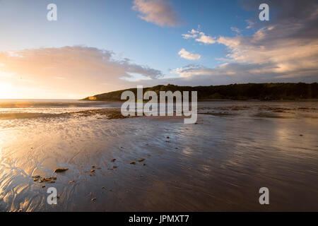 Sonnenuntergang am Strand bei Ebbe in Cemaes Bay, Anglesey Wales UK Stockfoto