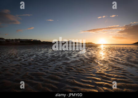 Sonnenuntergang am Strand bei Ebbe in Cemaes Bay, Anglesey Wales UK Stockfoto