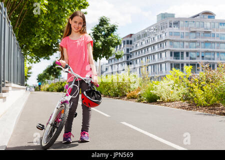 Glückliches Mädchen stehend mit Fahrrad auf Radweg Stockfoto