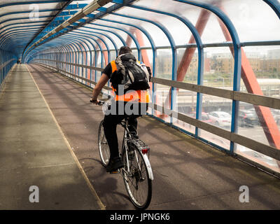 Radfahrerbrücke. Radfahrer fährt über die Tony Carter-Brücke, eine Rad- und Fußgängerbrücke, die die Hauptbahnstrecke in Cambridge UK überquert Stockfoto