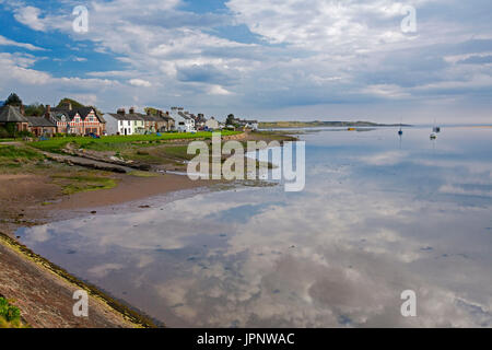 Waterfront Häuser neben Strand und Ruhe blaue Wasser des Ozeans im verschlafenen Dorf an der Küste von Ravenglass in Cumbria, England Stockfoto