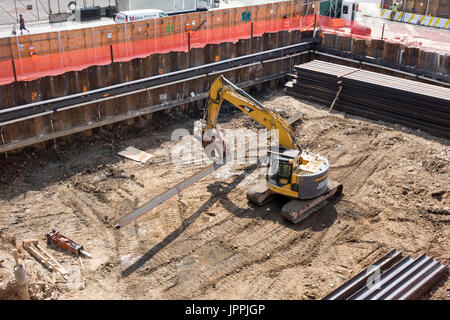 Eine nachverfolgte Eimer Bagger verwendet als rotierende Greifer Mover mit kontinuierlichen Spuren und Aufhebung Kran auf einer Baustelle in New York City Stockfoto