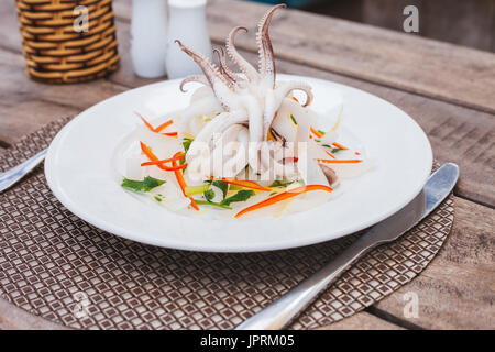 Delicious gedünsteter Tintenfisch mit Gemüse für gesunde Meeresfrüchte Menü auf Holztisch Stockfoto