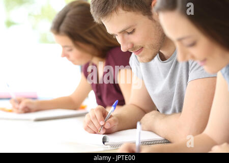 Nahaufnahme von drei Studenten Notizen im Klassenzimmer Stockfoto