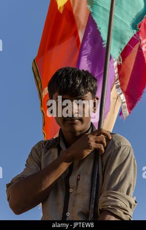 Ein junger indischer Junge hält eine Flagge auf einem Festival in Hampi, Karnataka, Indien Stockfoto