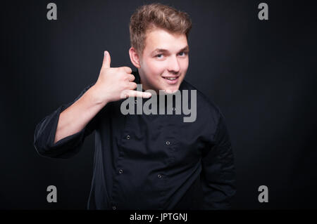 Kaukasische Jungkoch machen, rufen Sie mich Geste als catering oder Essen bestellen-Konzept Stockfoto
