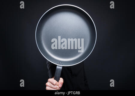 Männlichen Chef versteckt sich hinter einer Pfanne Kochen und Konzept Stockfoto