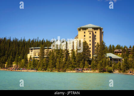 Viele Touristen genießen einen sonnigen Tag im das Fairmont Chateau Lake Louise in den kanadischen Rocky Mountains. Stockfoto