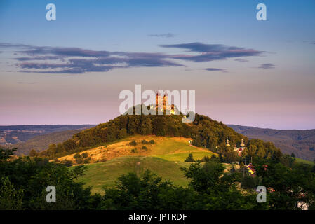 Obere Kirche mit zwei Türmen und barocken Kalvarienberg in Banska Stiavnica, Slovaka bei Sonnenuntergang. Banska Stiavnica ist eine vollständig erhaltene mittelalterliche Stadt und Stockfoto