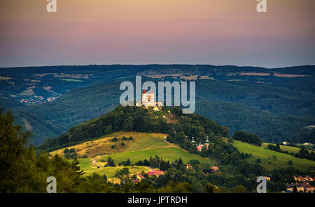 Obere Kirche mit zwei Türmen und barocken Kalvarienberg in Banska Stiavnica, Slovaka bei Sonnenuntergang. Banska Stiavnica ist eine vollständig erhaltene mittelalterliche Stadt und Stockfoto