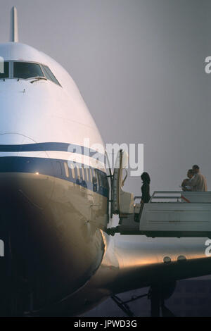 eine einsame Frau Passagiere einsteigen, Airstairs von einer Fernbedienung geparkt Luft China Boeing 747-400 Stockfoto