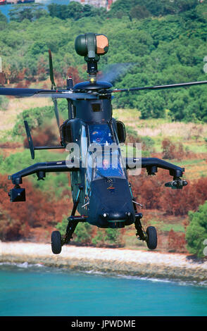 Eurocopter-Tigre-Prototyp mit Bäumen, Strand, Küste und Meer hinter fliegen Stockfoto