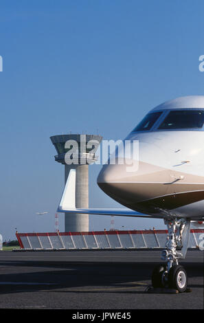 Gulfstream 500 mit Explosion Zaun und Flugverkehr Kontrollturm hinter Bugrad Fahrwerk und Winglet des Golfers Greg Norman Privatjet Stockfoto