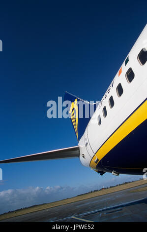 Schwanzflosse mit Logo, Horizontal-Stabilisator und hinteren Rumpf von Ryanair Boeing 737-800 mit einer nassen Schürze nach einem Regenschauer Stockfoto