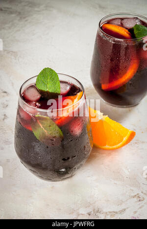 Traditionelle spanische Sommer erfrischenden Drink, Cocktail, Tinto de Verano. Mit Wein, Eis und Stücke von frischem Orange. Am weißen Stein Tisch kopieren Sie Raum Stockfoto