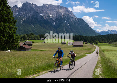 Radler fahren durch Wiesen bei Mittenwald in den bayerischen Alpen Stockfoto