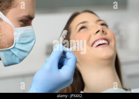 Nahaufnahme von einem Zahnarzt Hand zeigt ein Implantat zu einem Patienten in einem Büro Stockfoto