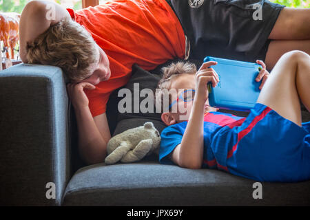 Young Boy Computer Spiel auf Tablet mit anderen Jungen beobachten Stockfoto