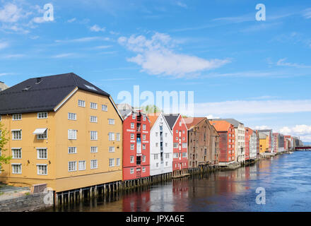 Bunte historische hölzerne Lagergebäude auf Stelzen am Fluss Nidelva Wasser in der alten Stadt im Sommer. Trondheim Norwegen Skandinavien Stockfoto