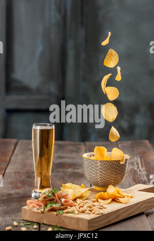 Bierglas und Kartoffel-Chips, Pistazien isoliert auf einem weißen Stockfoto