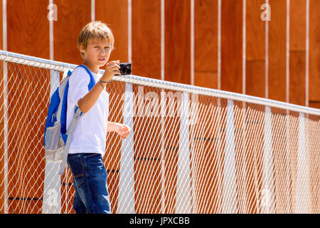 Kleiner Junge mit einer Digitalkamera fotografieren auf der Straße Stockfoto